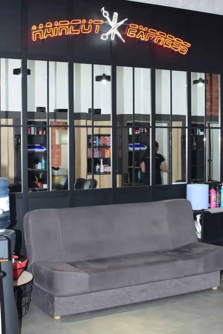 Strefa oczekiwania z kanapą w salonie Haircut Express przy ul. Cybernetyki 15